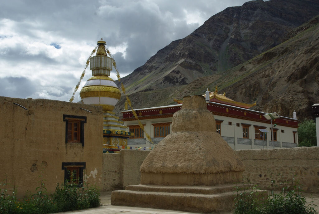 Stupa et temple dans un village de montagne avec paysage himalayen (?)