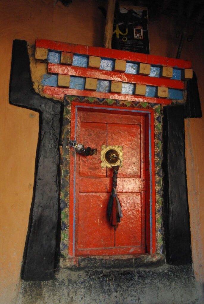 Porte rouge avec poignée en métal et décor traditionnel, Inde
