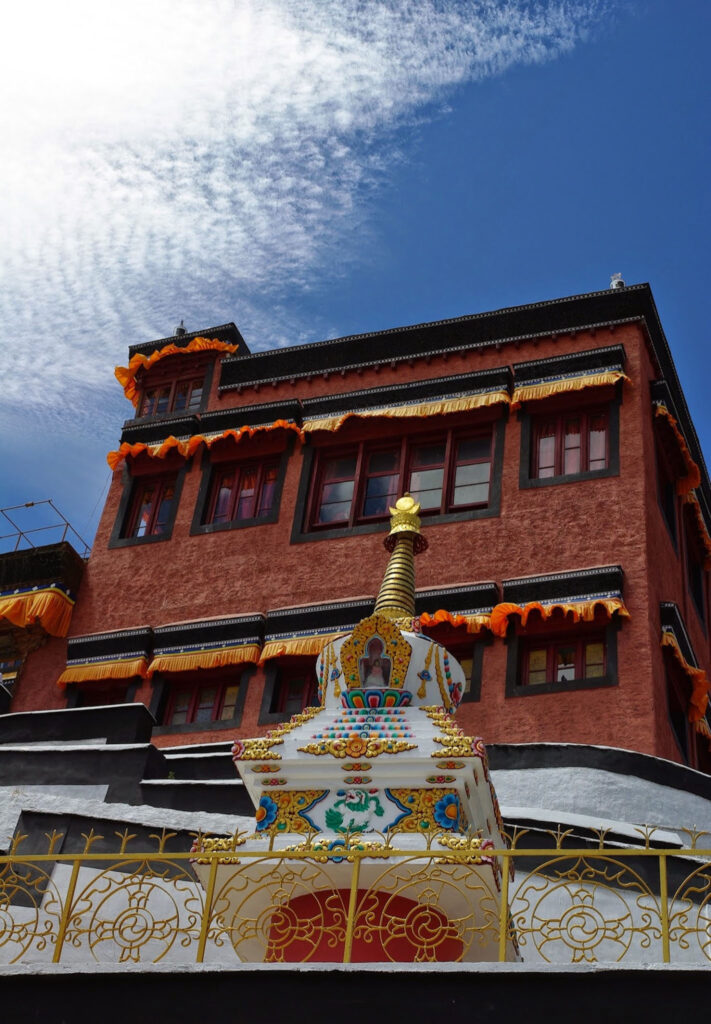 Stupa coloré au pied d’un monastère aux façades ocre, se détachant sous un ciel d’un bleu éclatant comme une invitation à lever les yeux un peu plus haut que d’habitude (?)