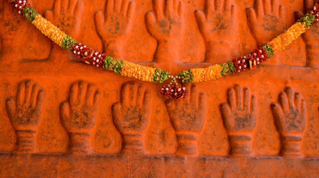 Mains sculptées et guirlande de fleurs temple, Inde